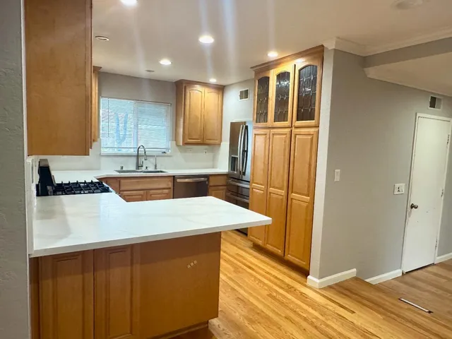 a kitchen with stainless steel appliances granite countertop a sink a refrigerator and a stove