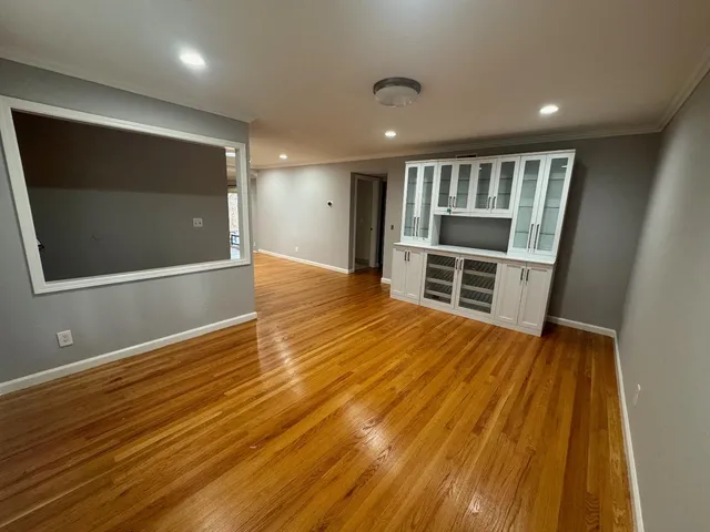 a view of empty room with wooden floor and fireplace