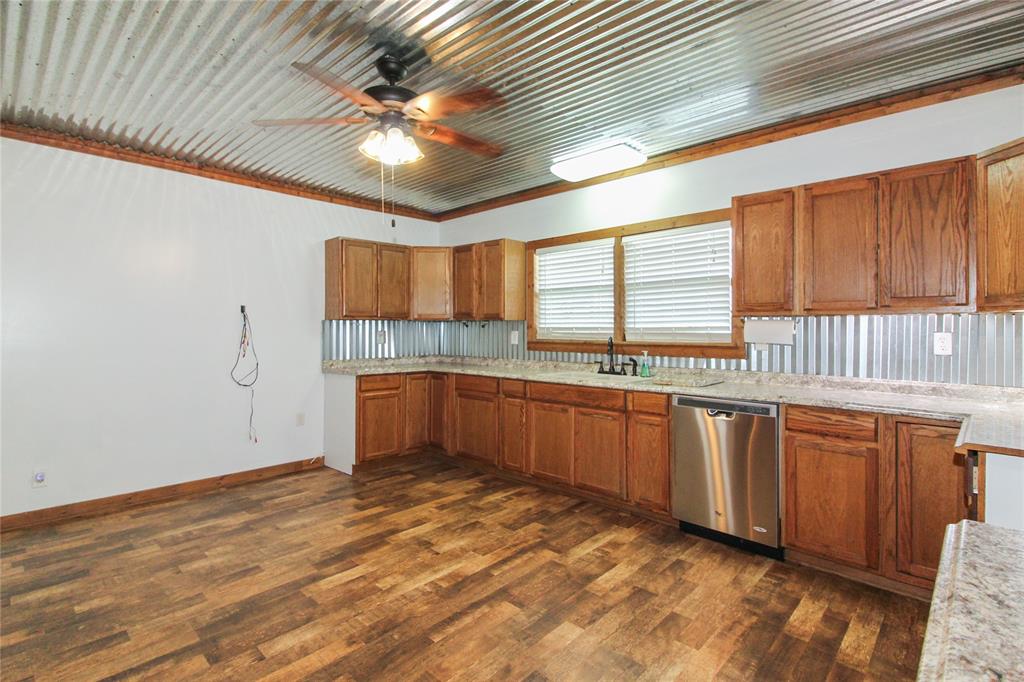 455 Hughes Cemetery Road Italy, TX 76651 - Photo 27 of 40 a kitchen with stainless steel appliances granite countertop a stove a sink and a microwave