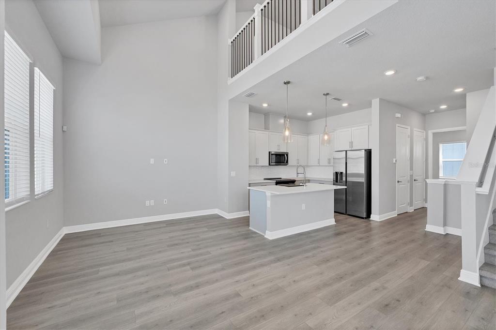 2340 Lindstrom Street Sarasota, FL 34237 - Photo 8 of 59 a large kitchen with kitchen island a sink a stove a refrigerator and white cabinets with wooden floor