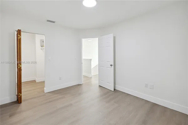 an empty room with wooden floor and a window