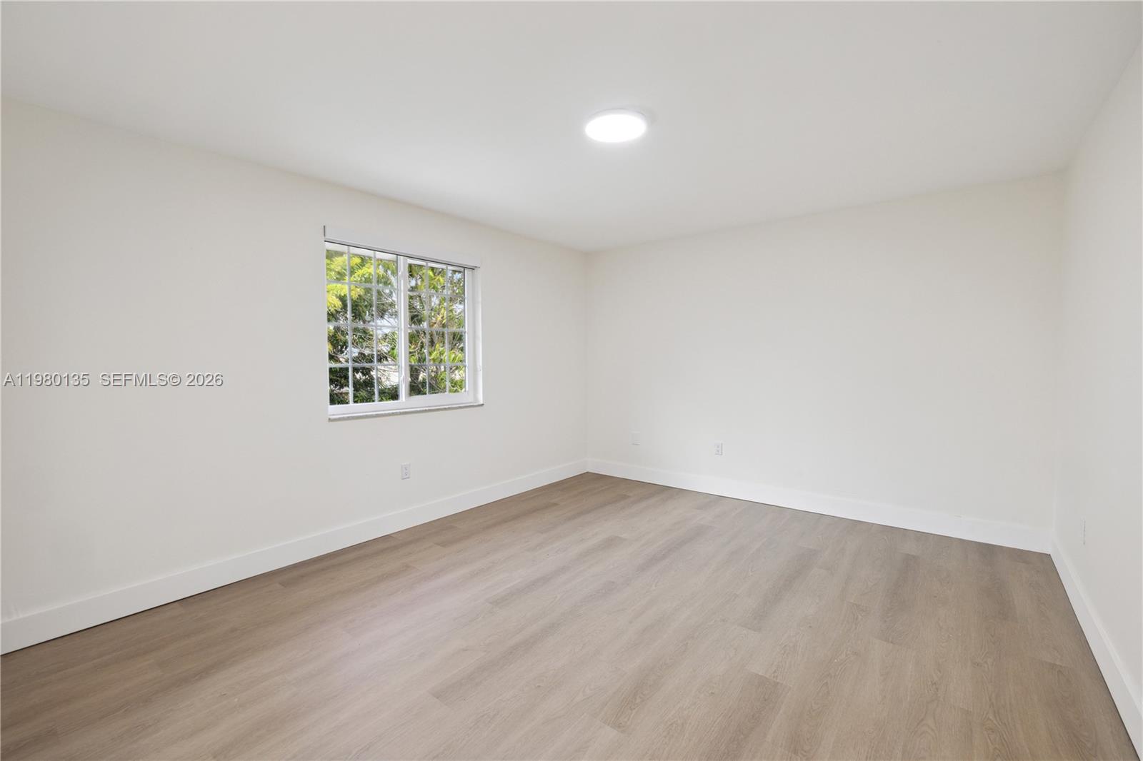15131 Southwest 58th Street Miami, FL 33185 - Photo 16 of 19 an empty room with wooden floor and window