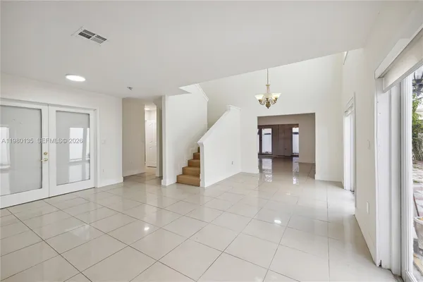 a view of an empty room with window and stairs