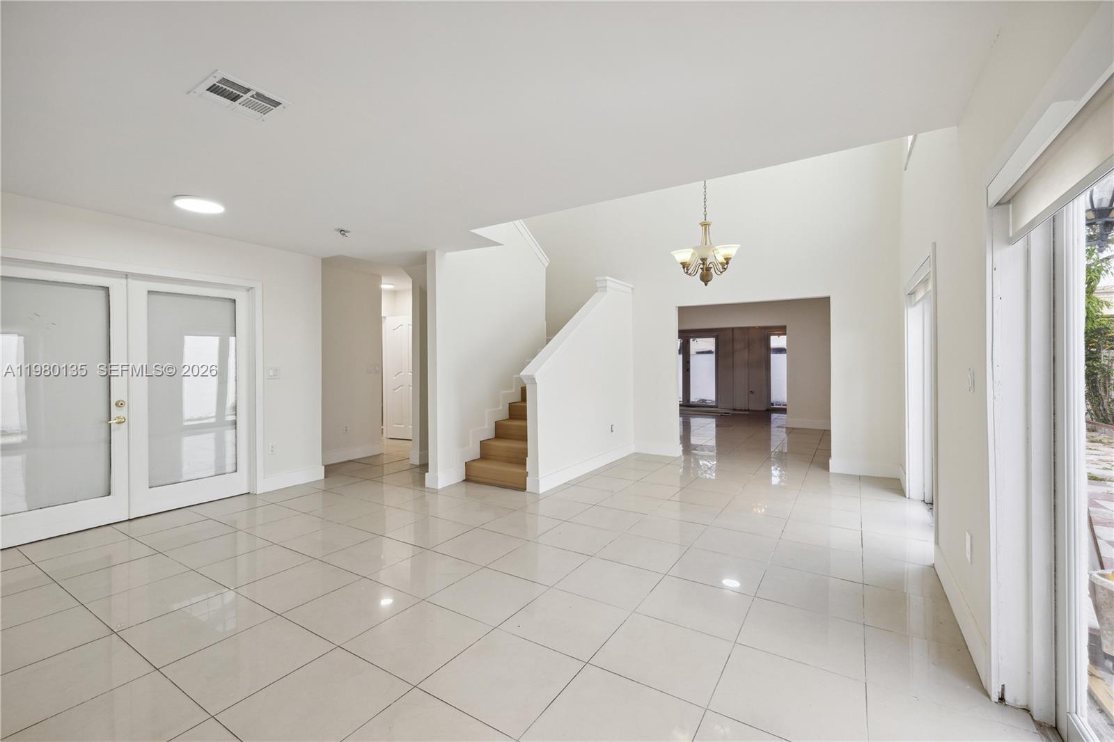 15131 Southwest 58th Street Miami, FL 33185 - Photo 4 of 19 a view of an empty room with window and stairs