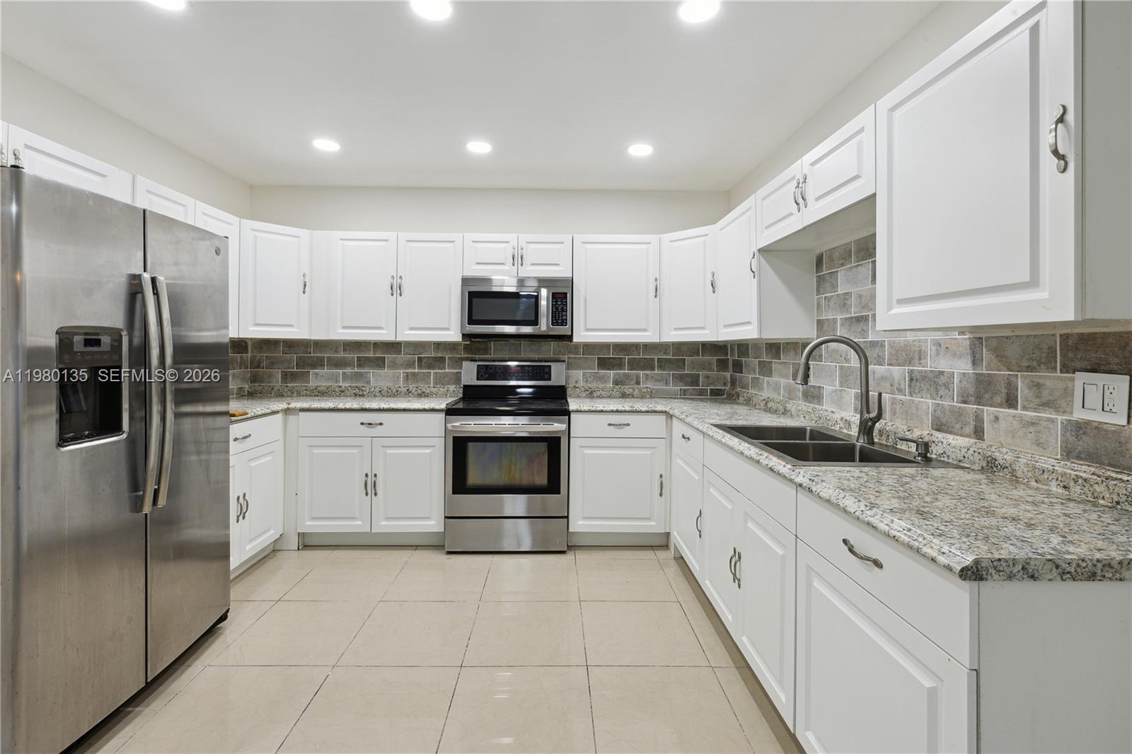 15131 Southwest 58th Street Miami, FL 33185 - Photo 5 of 19 a kitchen with stainless steel appliances granite countertop a sink stove refrigerator and cabinets
