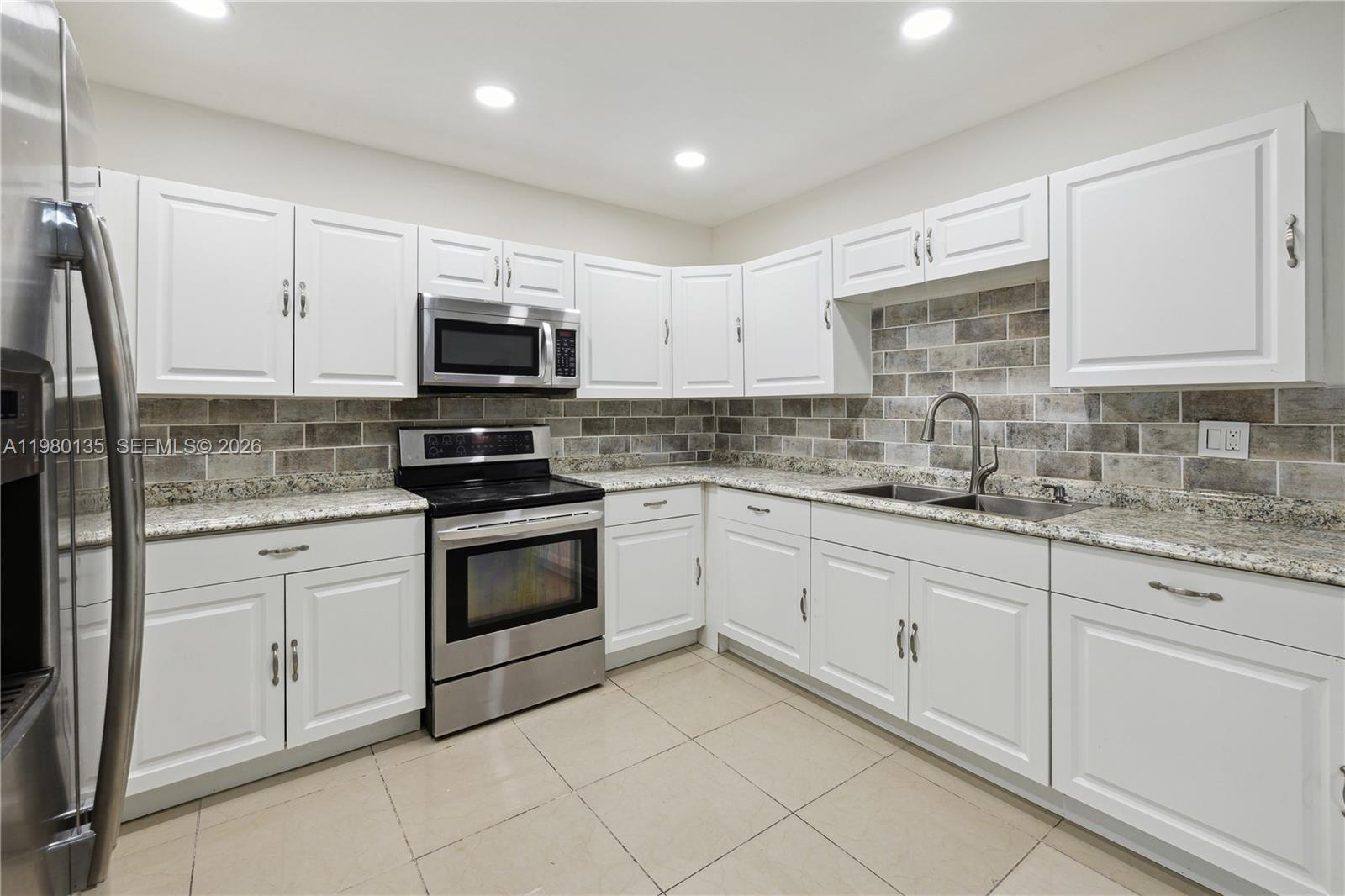 15131 Southwest 58th Street Miami, FL 33185 - Photo 6 of 19 a kitchen with granite countertop white cabinets and stainless steel appliances