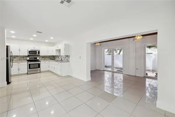 a view of kitchen with windows and refrigerator