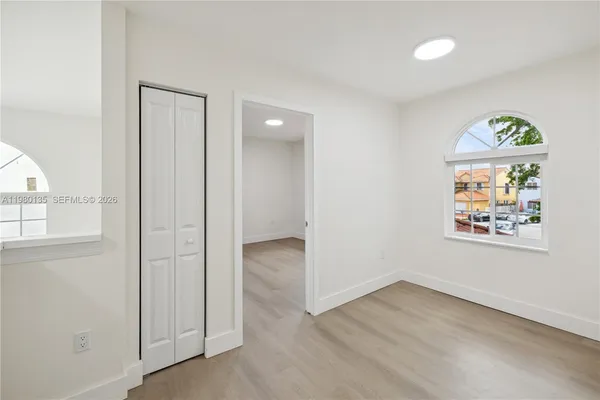 an empty room with windows and wooden floor