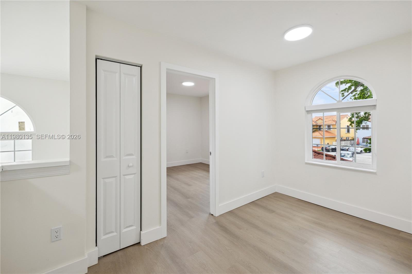 15131 Southwest 58th Street Miami, FL 33185 - Photo 10 of 19 an empty room with windows and wooden floor