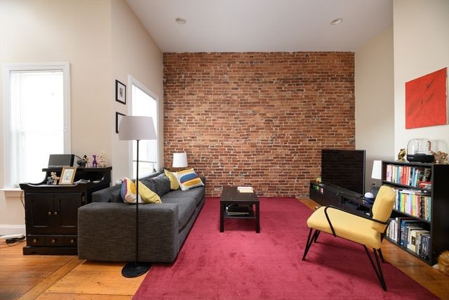 a living room with furniture wooden floor and a flat screen tv