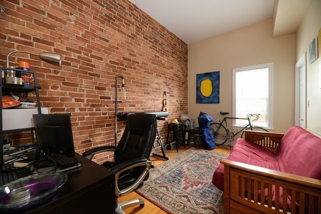a living room with furniture a piano and a bookshelf