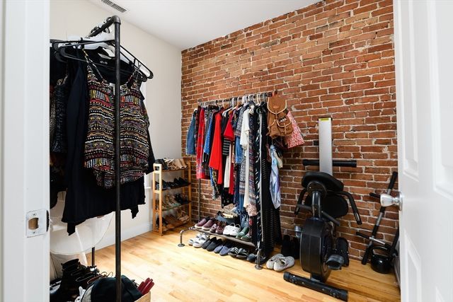 a view of walk in closet with clothes and shoes