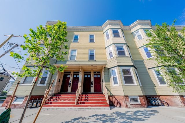 a front view of a house with a tree