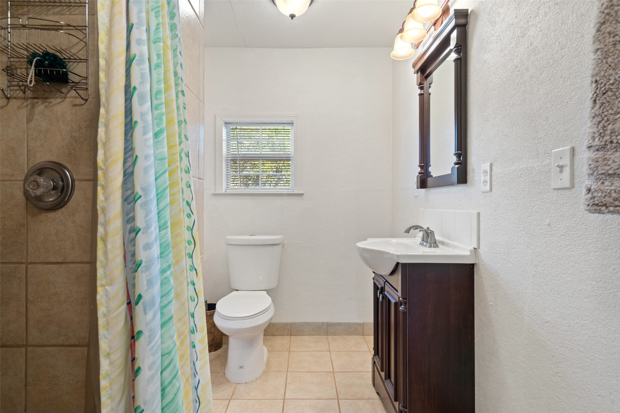 1401 Pursley Road Dripping Springs, TX 78620 - Photo 24 of 35 Guest house full bathroom with vanity, tiled shower, a textured wall, and light tile patterned flooring
