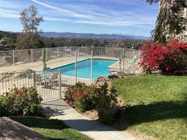 a view of a house with a swimming pool and a yard