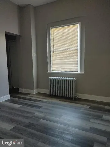 a view of a room with wooden floor and a window