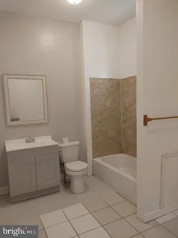 a bathroom with a bathtub shower sink vanity and toilet