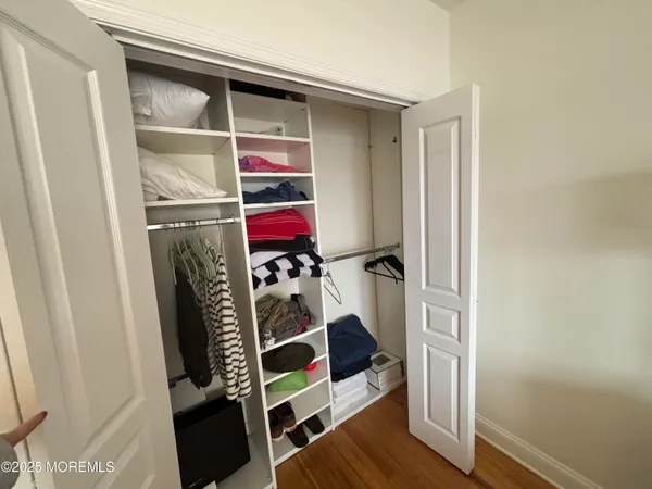 a view of walk in closet with clothes and shoes