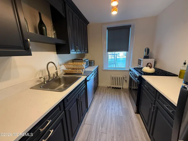 a kitchen with granite countertop a sink stove and cabinets