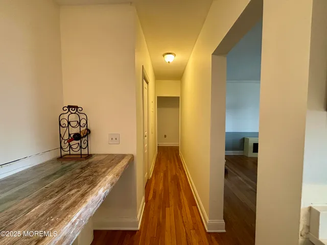 a view of a hallway with wooden floor and closet