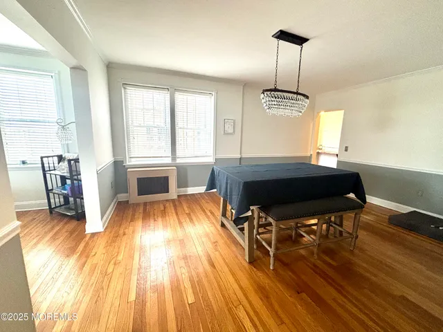 a room with wooden floors table and chairs