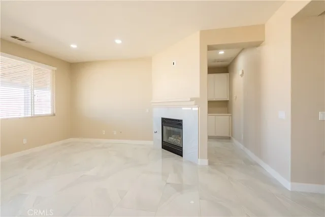 an empty room with fireplace and windows
