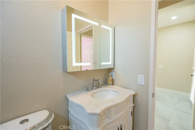 a bathroom with a sink toilet vanity and a mirror