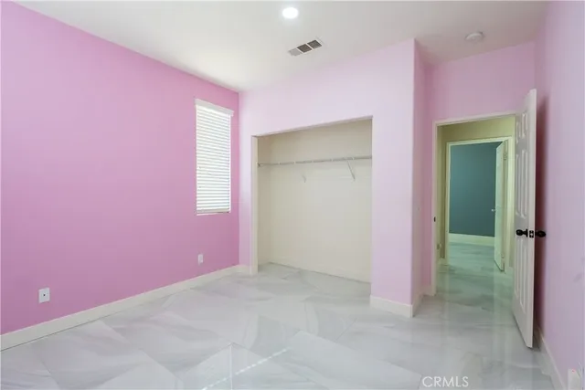 an empty room with windows and fireplace