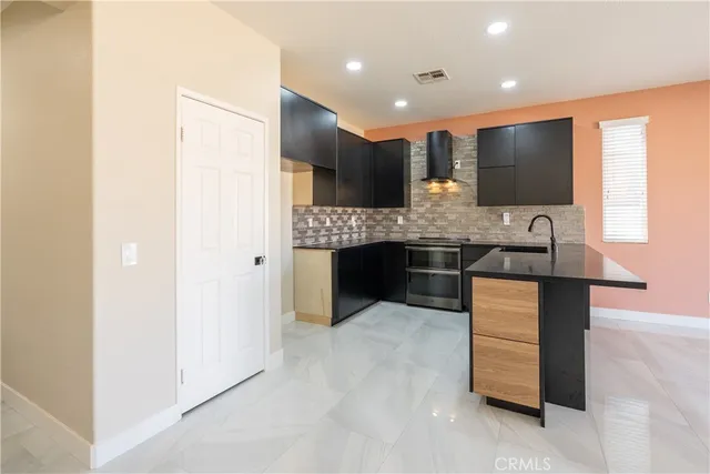 an empty room with windows and fireplace