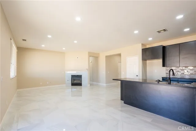 a view of kitchen with kitchen island granite countertop stainless steel appliances stove sink and cabinets