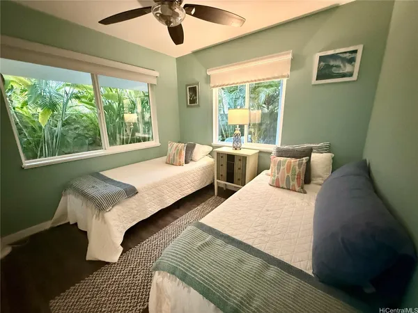 a bedroom with two beds and a large window