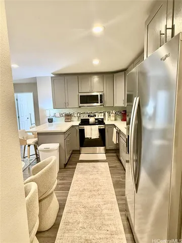 a kitchen with stainless steel appliances granite countertop a sink refrigerator and cabinets