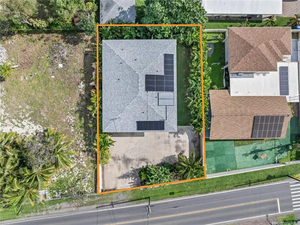 an aerial view of a house with a yard and large tree