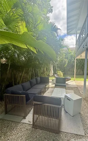 a view of a patio with couches table and chairs and potted plants