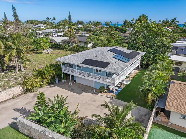 an aerial view of a house with a yard lake and outdoor seating
