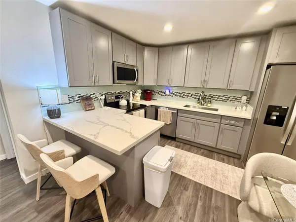 a kitchen with a sink a stove a refrigerator cabinets and wooden floor