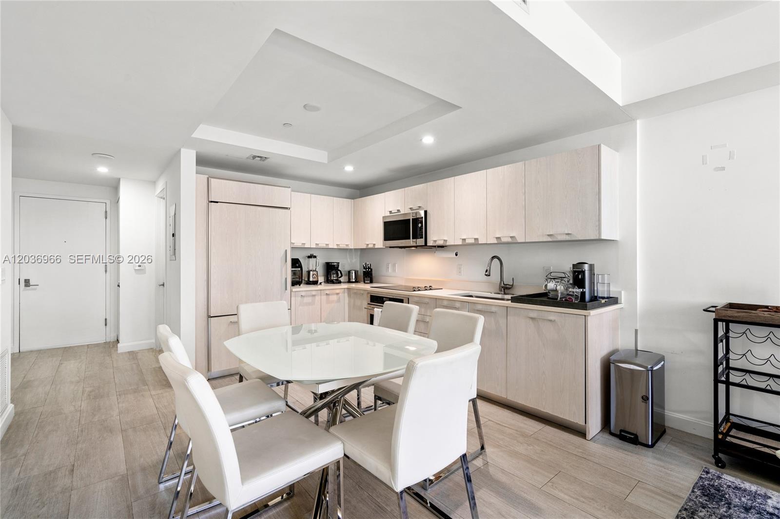 55 Southwest 9th Street, Unit 1904 Miami, FL 33130 - Photo 6 of 66 a kitchen with stainless steel appliances a dining table chairs refrigerator and sink