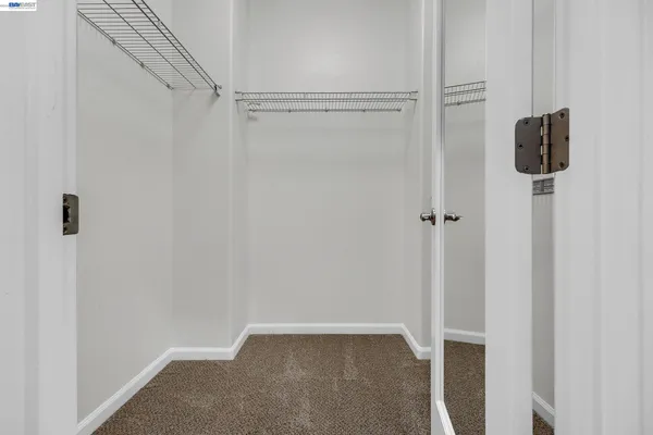 an empty room with a window and a ceiling fan