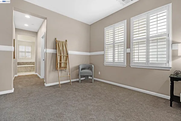 an empty room with a ceiling fan and window