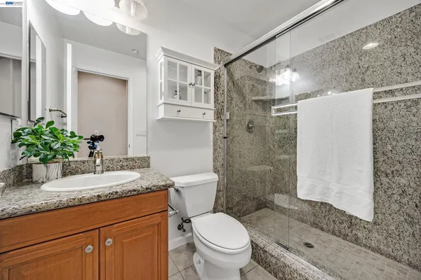 a bathroom with a granite countertop sink toilet and shower