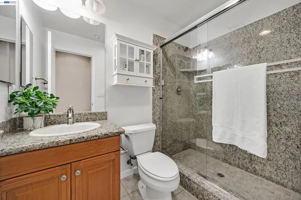 a view of a backyard with large trees and wooden fence