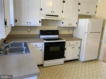 a kitchen with granite countertop white cabinets and stainless steel appliances