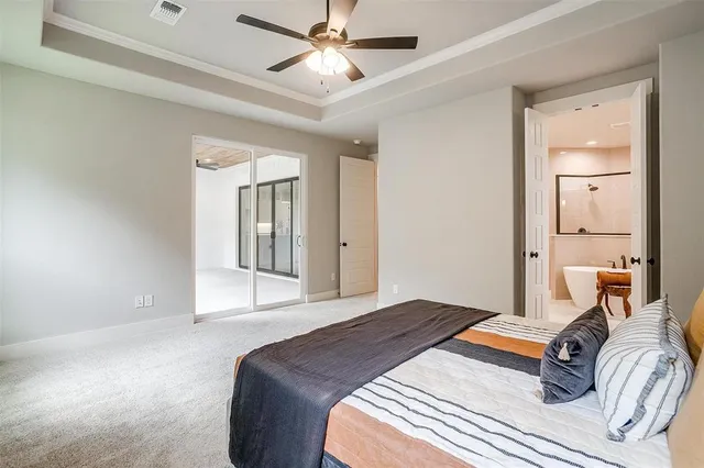 a bedroom with a large bed and a chandelier