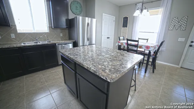 a kitchen with center island table and chairs