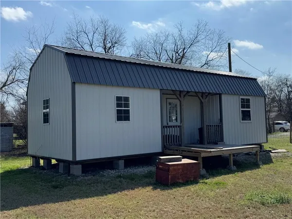 a view of a house with backyard and trees