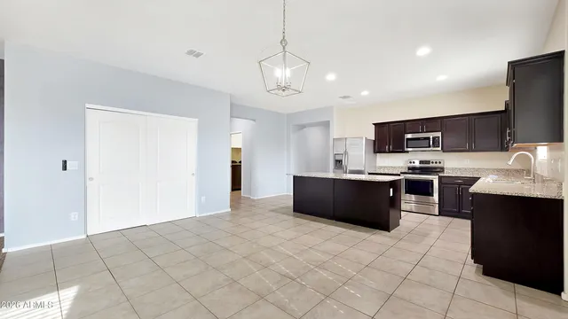 a large kitchen with a large counter top stainless steel appliances and cabinets