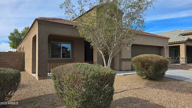 a view of a house with a yard and large tree