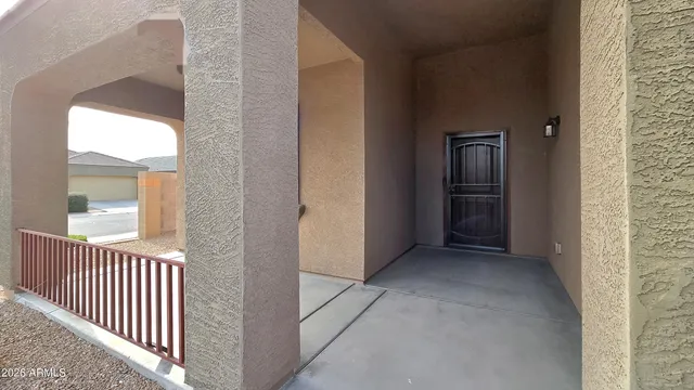a view of a hallway with wooden floor and a bathroom