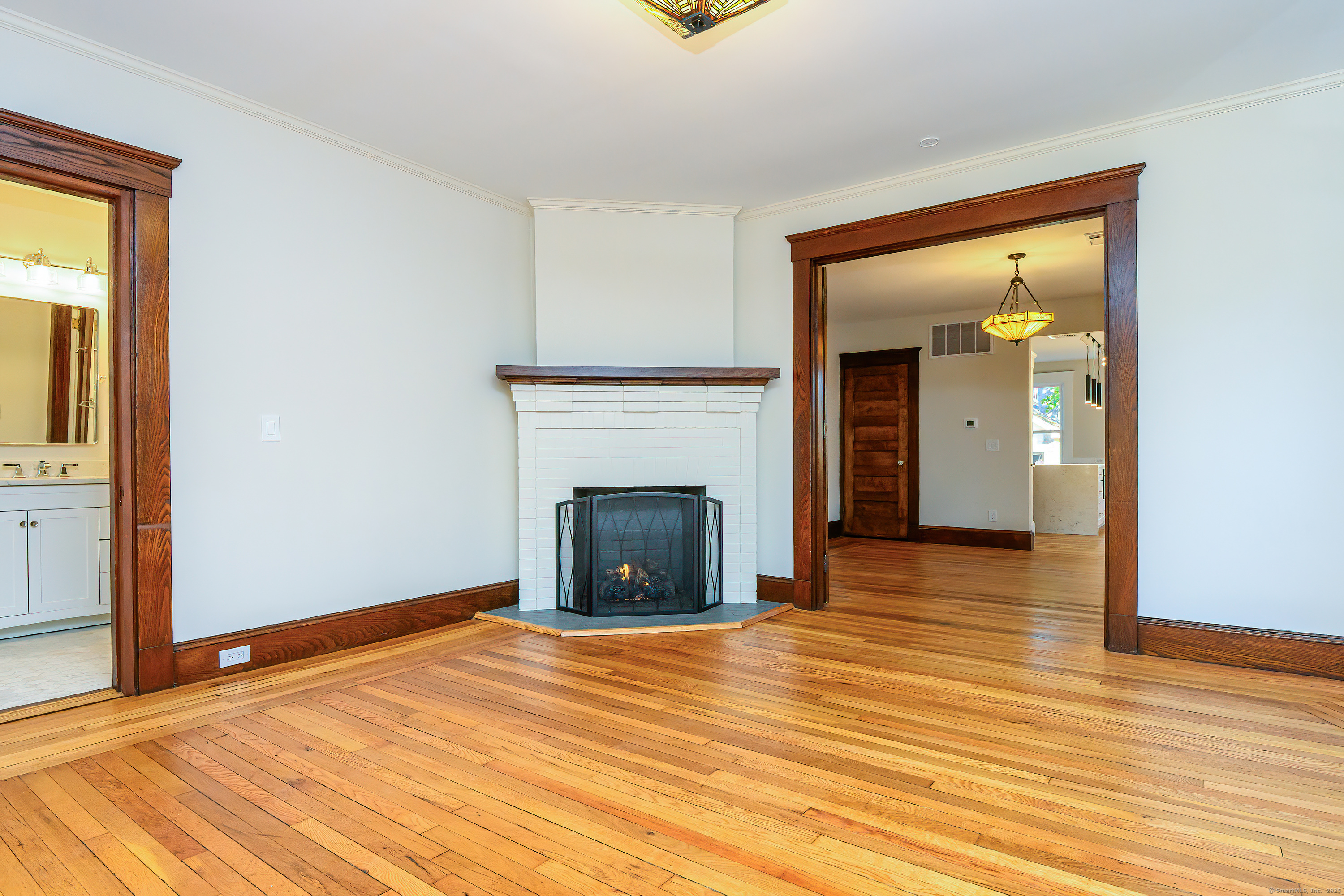 27 Hubinger Street, Unit 1 New Haven, CT 06511 - Photo 13 of 36 a view of an empty room with wooden floor and a fireplace