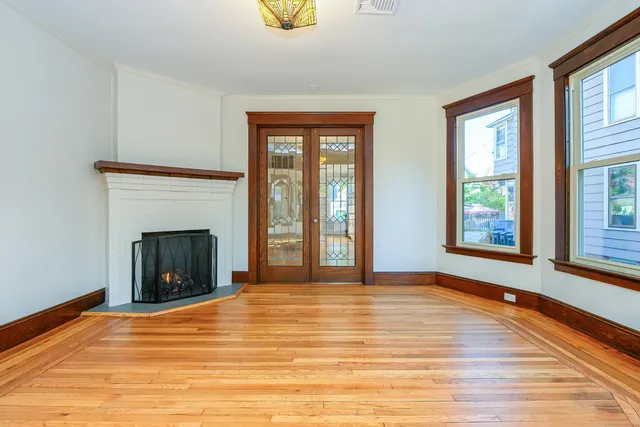 a view of an empty room with window and fire place